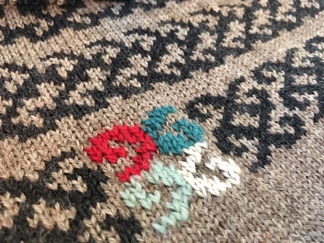 Two-color fair isle knitted fabric from punch card symmetry designs, with additional color applique
