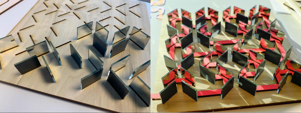 The mirrors themselves were then placed in the slits. The symbolic “laser beam” consists of a red piece of paper, cut with a laser cutter, resting on a wooden platform of the same shape.